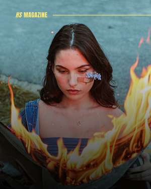 Jeune femme entourée de flammes, regard vers le bas, fleurs bleues sur le visage, illustrant la résilience face au chaos du monde.