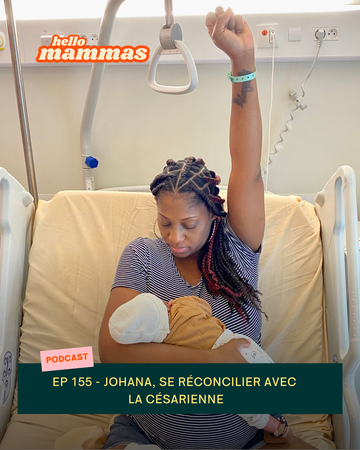 Une maman qui vient d'accoucher avec le poing en l'air et son bébé dans les bras